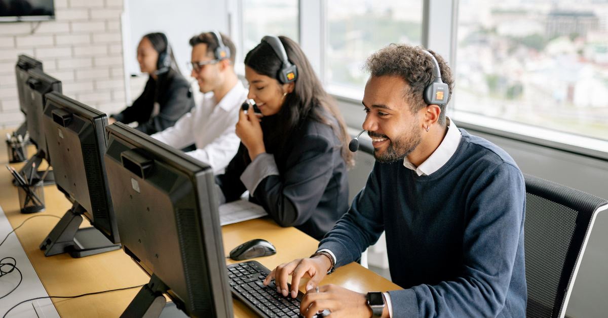 contact center team talking on headphones and working on computers