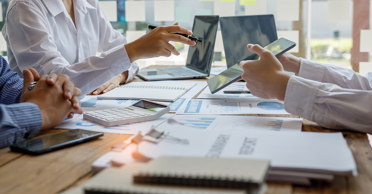 executive team collaboration at a table reviewing reports