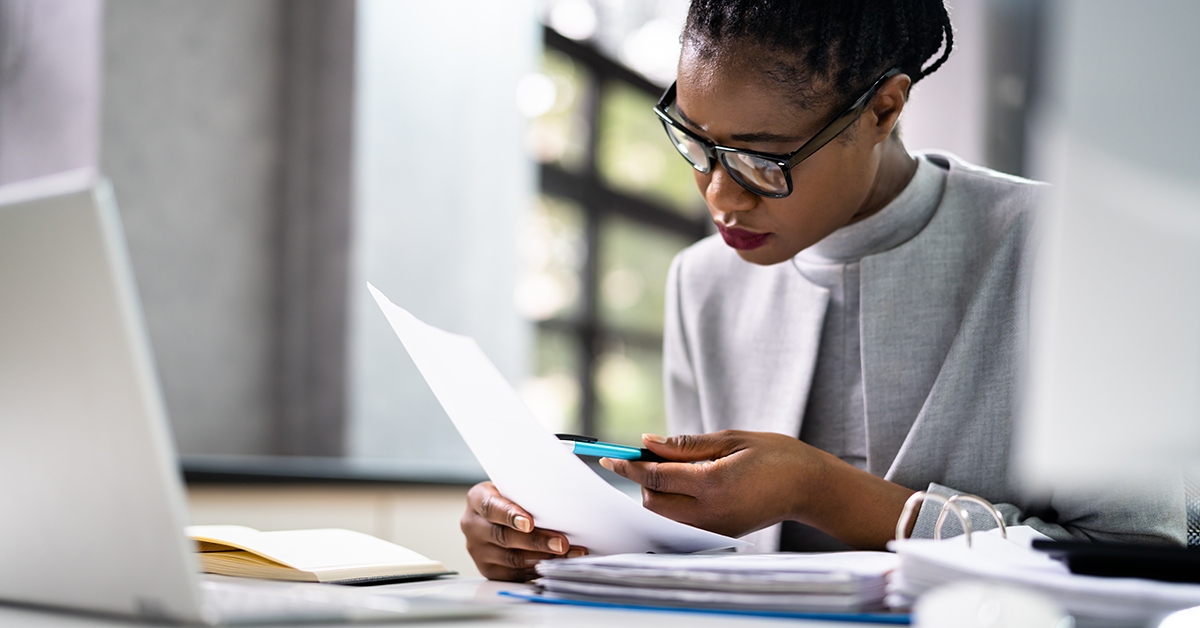 an auditor reviewing paperwork at a desk