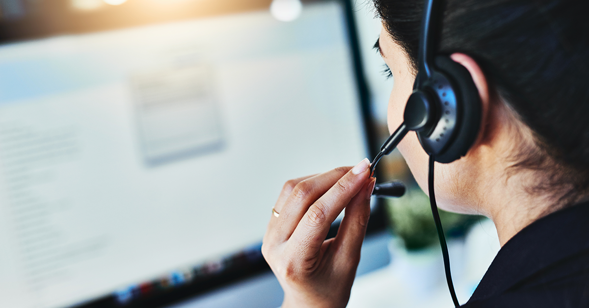 call center representative looking at a computer screen and talking