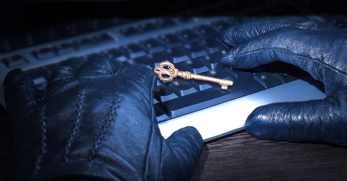 key sitting on a keyboard with gloved hands nearby