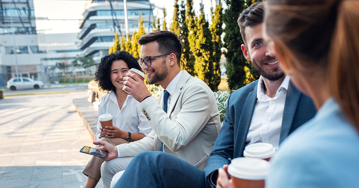 team taking a break outside and drinking coffee