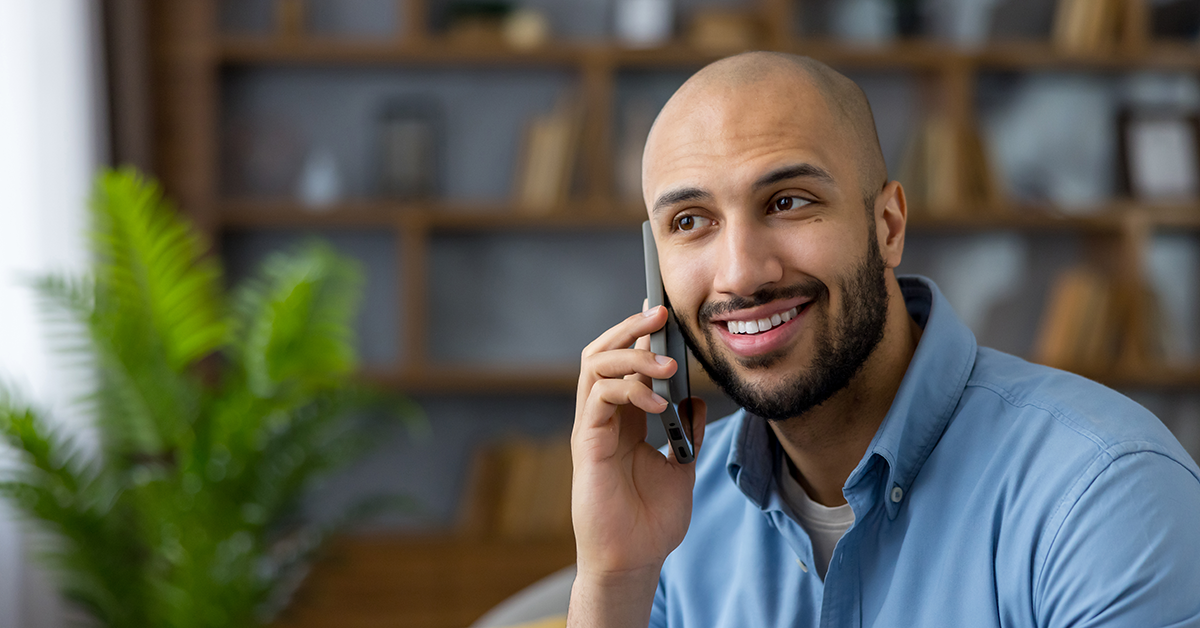 a smiling man talking on the phone