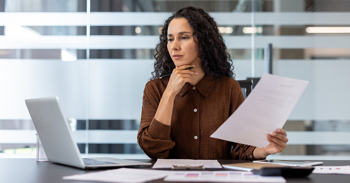 a woman reviewing documents in an office