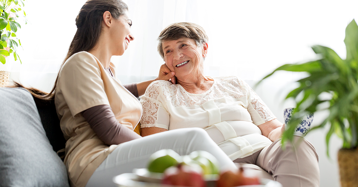 younger woman sitting with an elderly woman