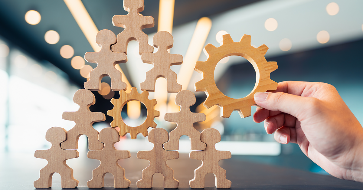 gears and people wood figures showing building community