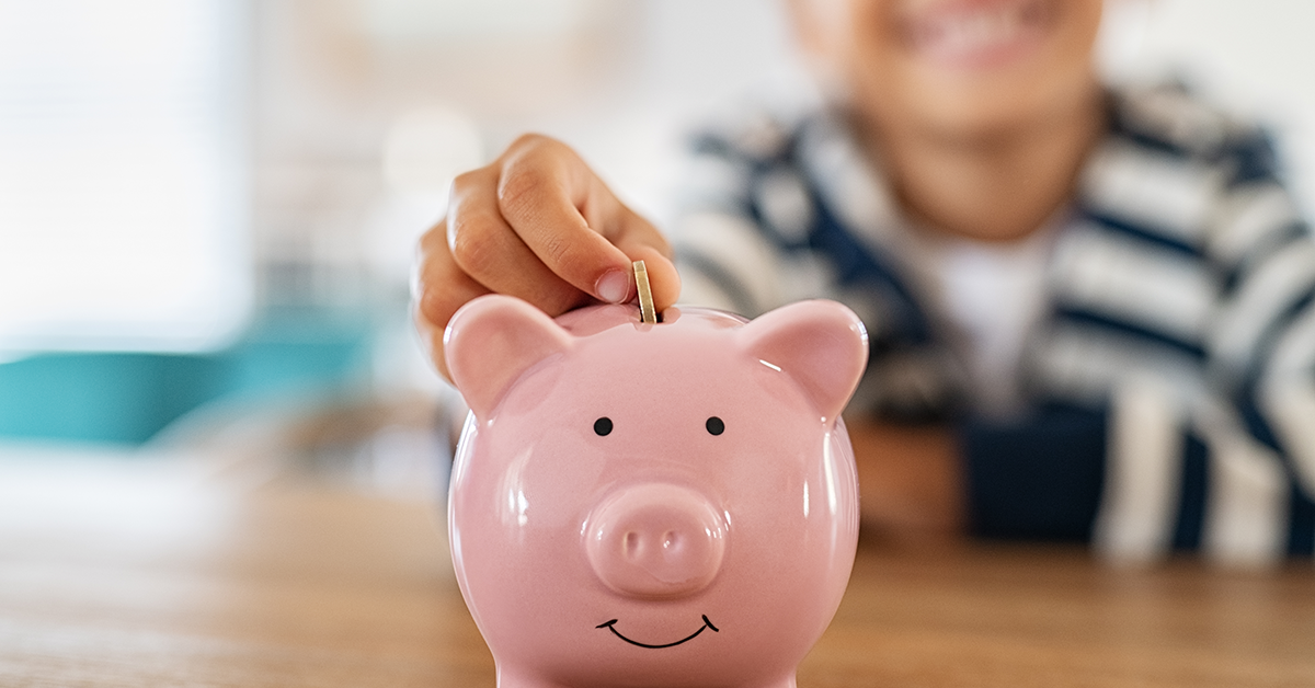 A child putting coins into a piggy bank