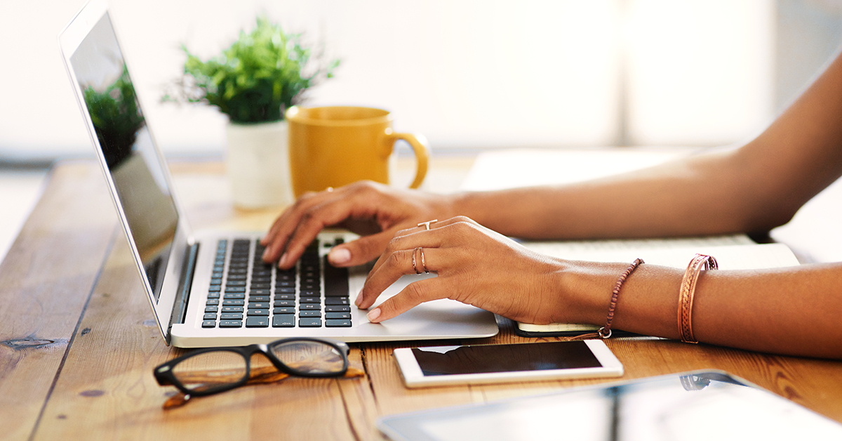 a woman's hands typing on a laptop keyboard