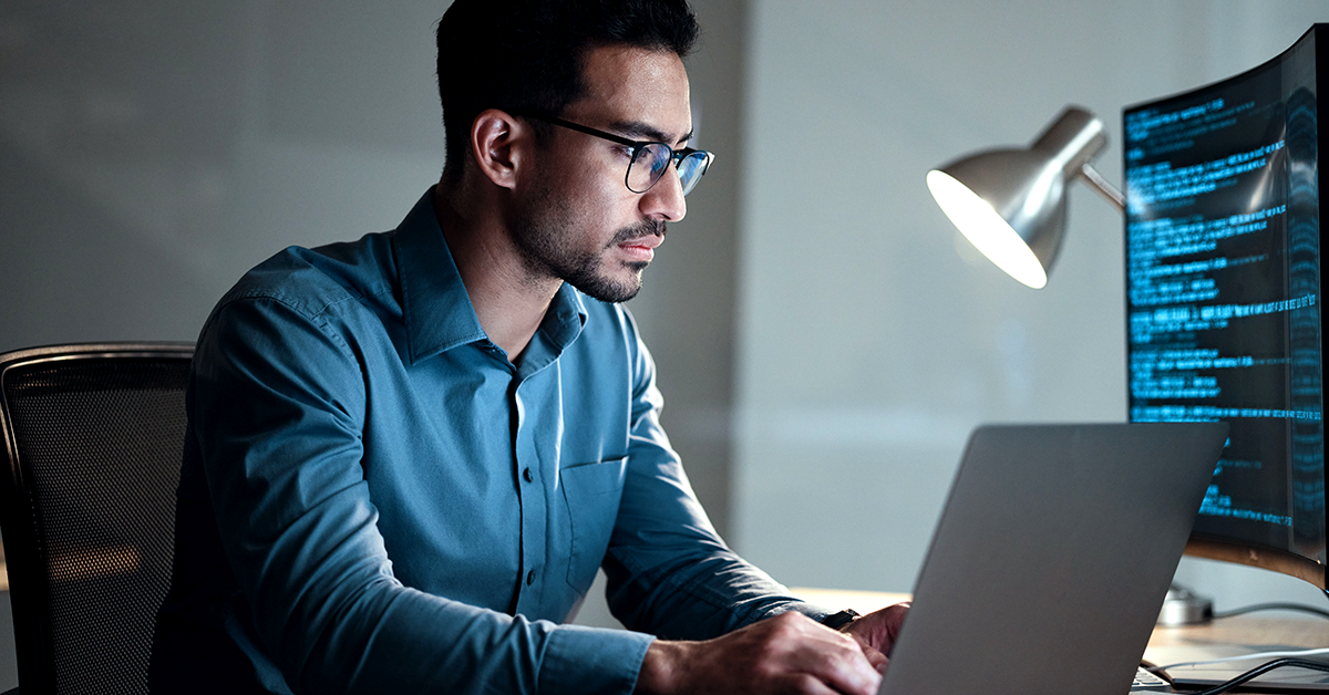 a man working on his computer at a desk
