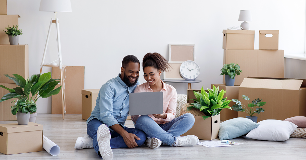 new smiling home owners looking at a computer