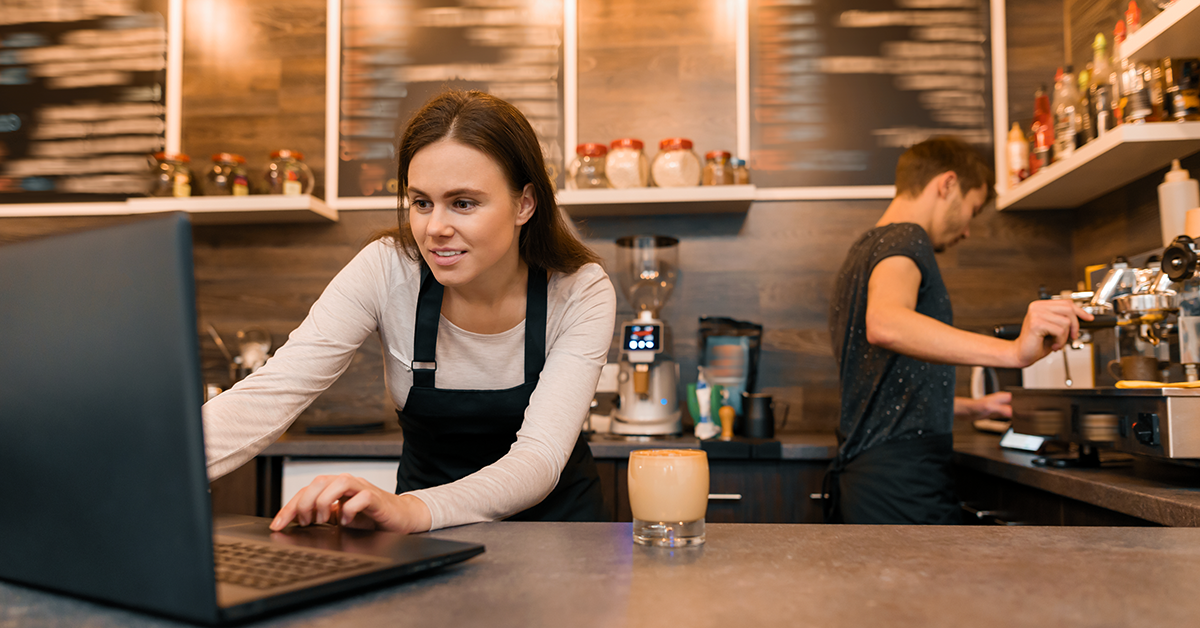 small cafe business owner working on a laptop