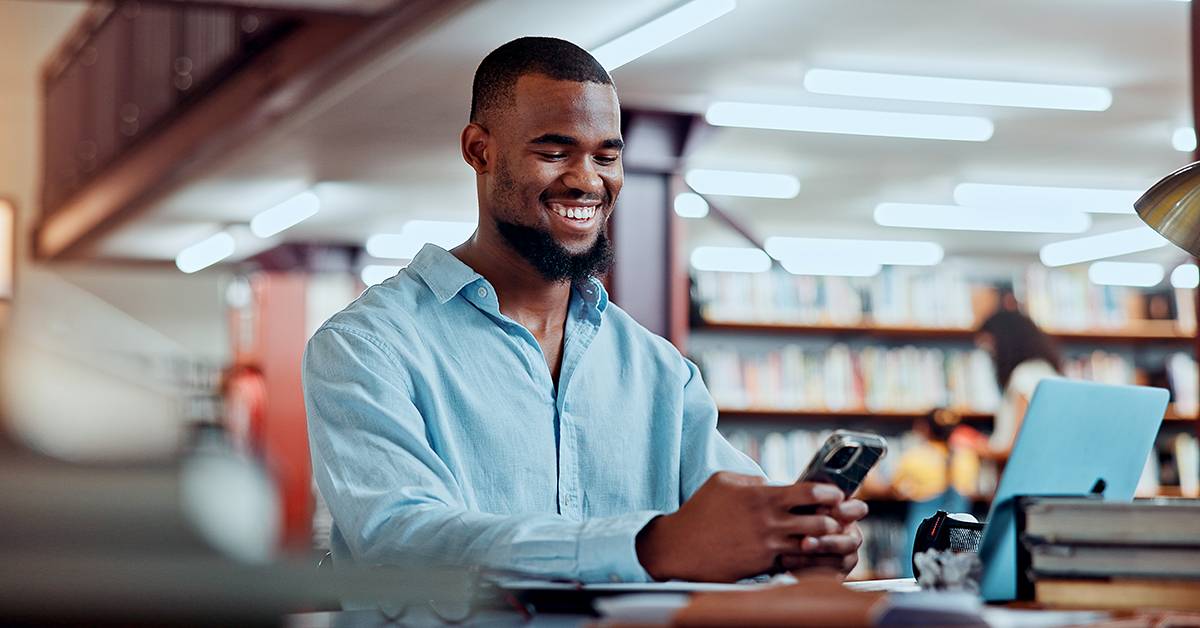 smiling young man studying at a library