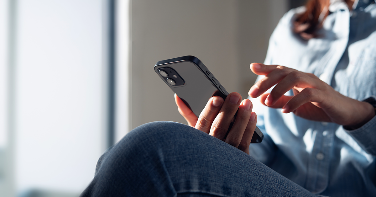 woman texting while relaxing on a couch