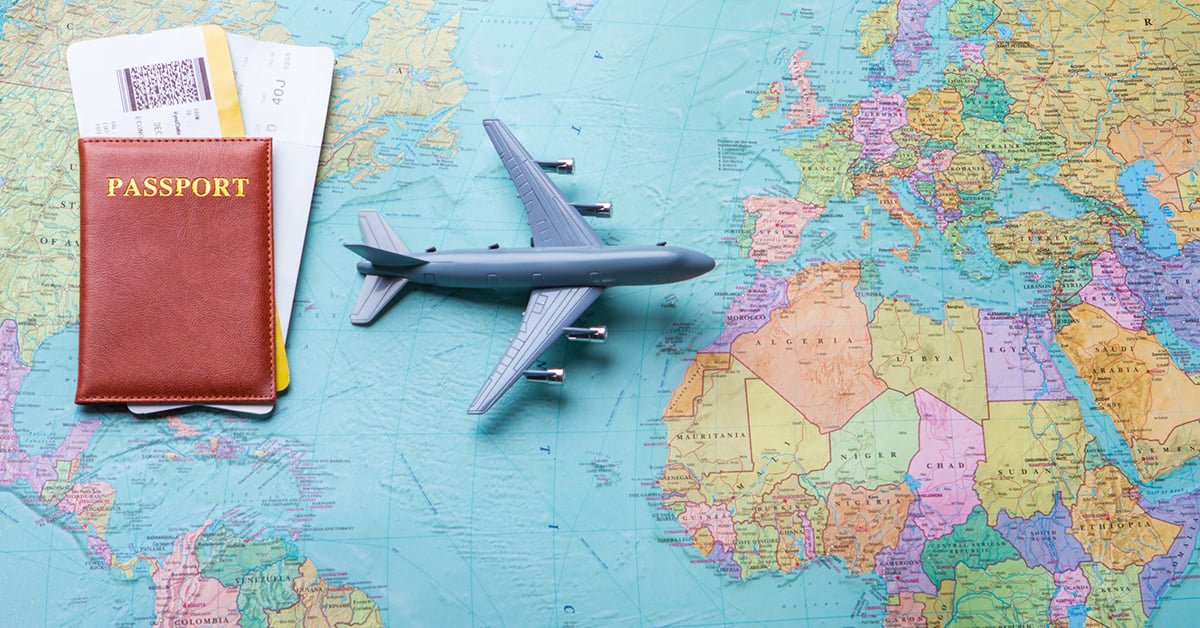 airplane model and passport sitting on top of a world map