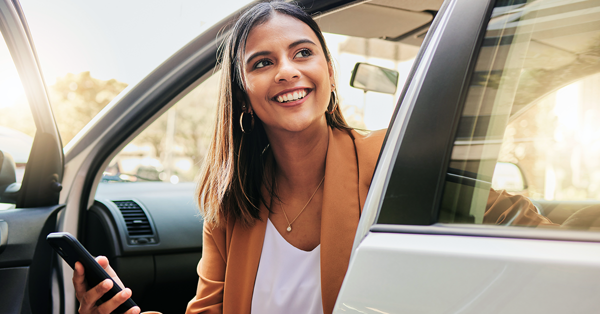 a woman sitting in a new car with keys in her hands