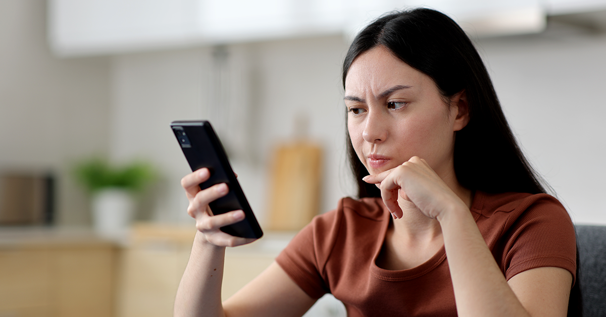 woman looking at her phone in a confused manner