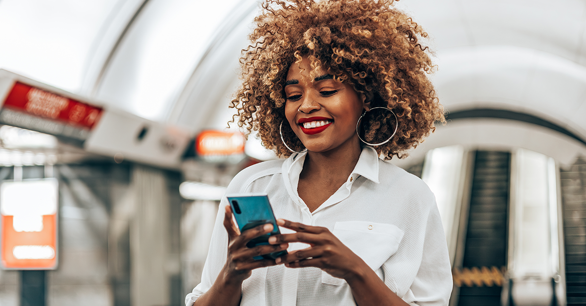smiling woman traveling and looking at her phone