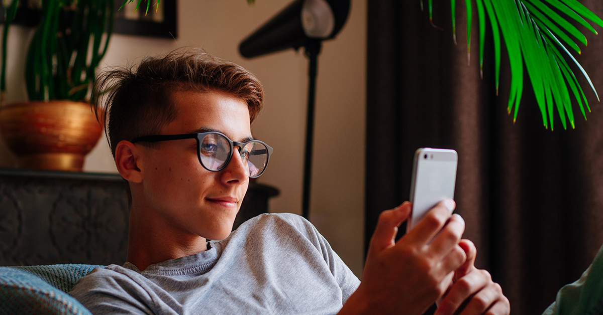 smiling young adult looking at his phone