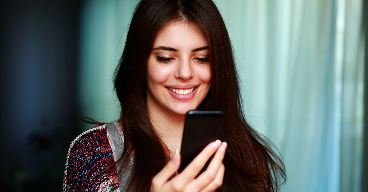 young smiling woman looking at a phone